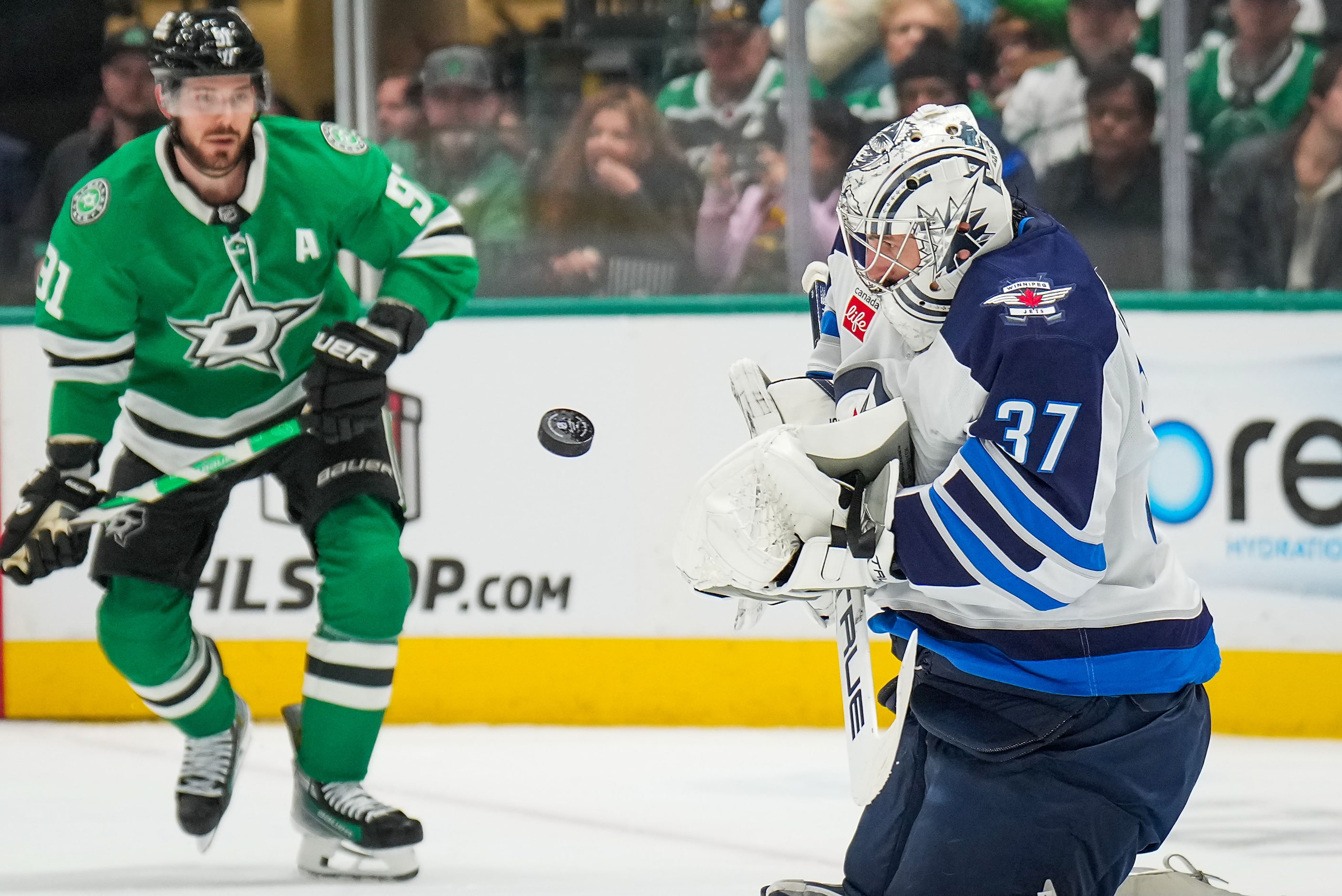 Winnipeg Jets goaltender Connor Hellebuyck (37) makes a save as Dallas Stars center Tyler...