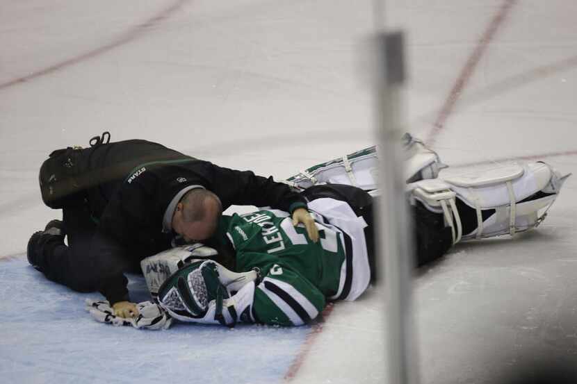 Dallas Stars goalie Kari Lehtonen (32) is tended to after being hit by Minnesota Wild left...