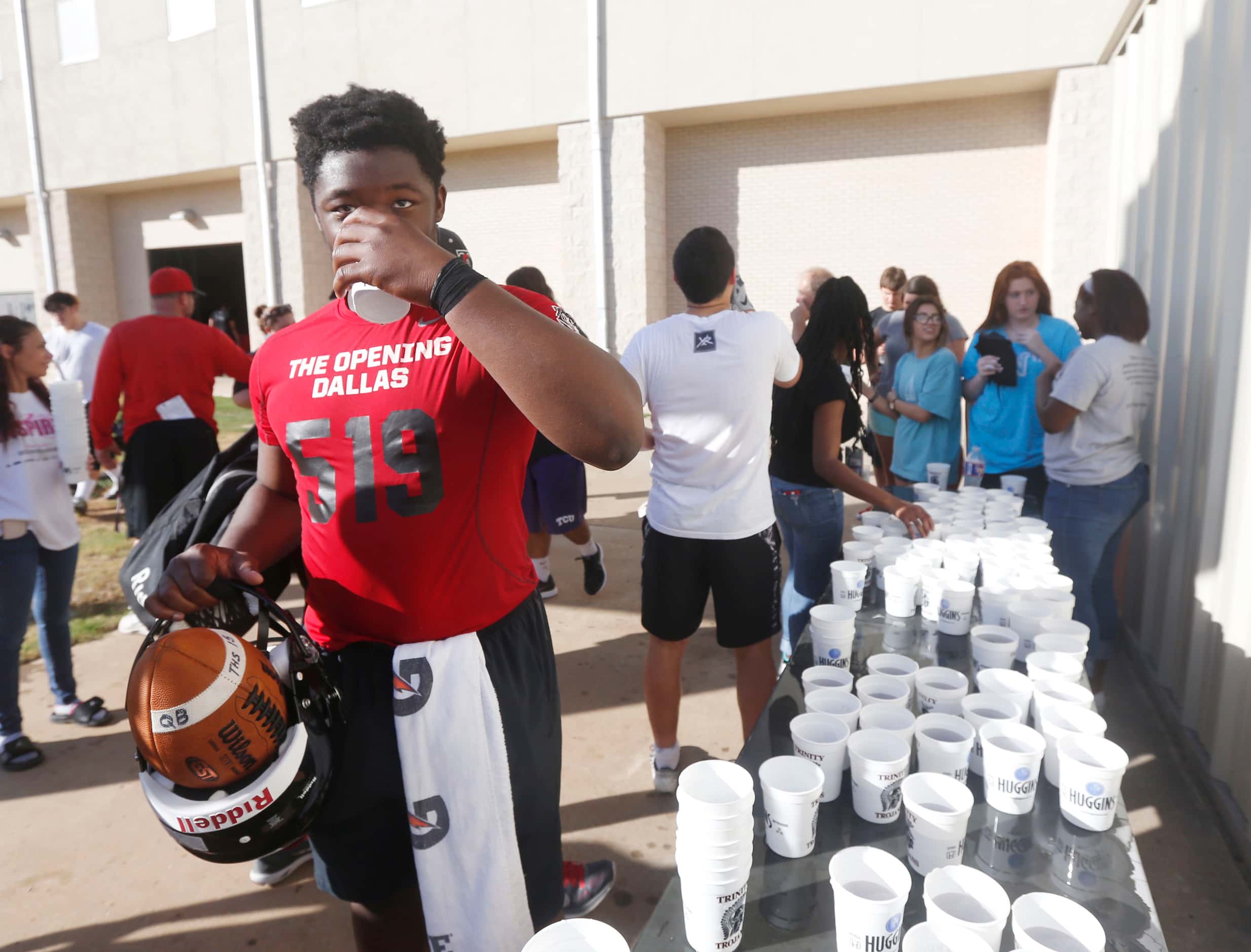 Quarterback Tyler Natee grabs a gatorade during Euless Trinity's first day of football...