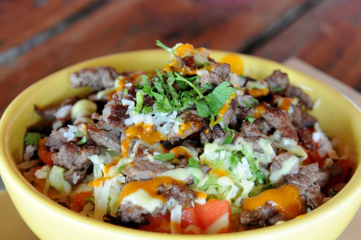 The bistek bowl features mixed greens, rice, beans, and cheese at La Ventana in Addison, TX...