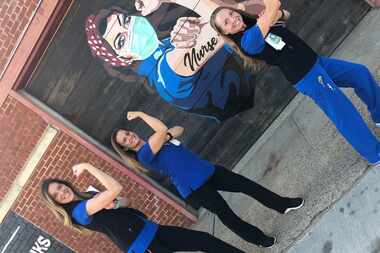 Three Parkland nurses stand in front of an empowering mural and flex their biceps.