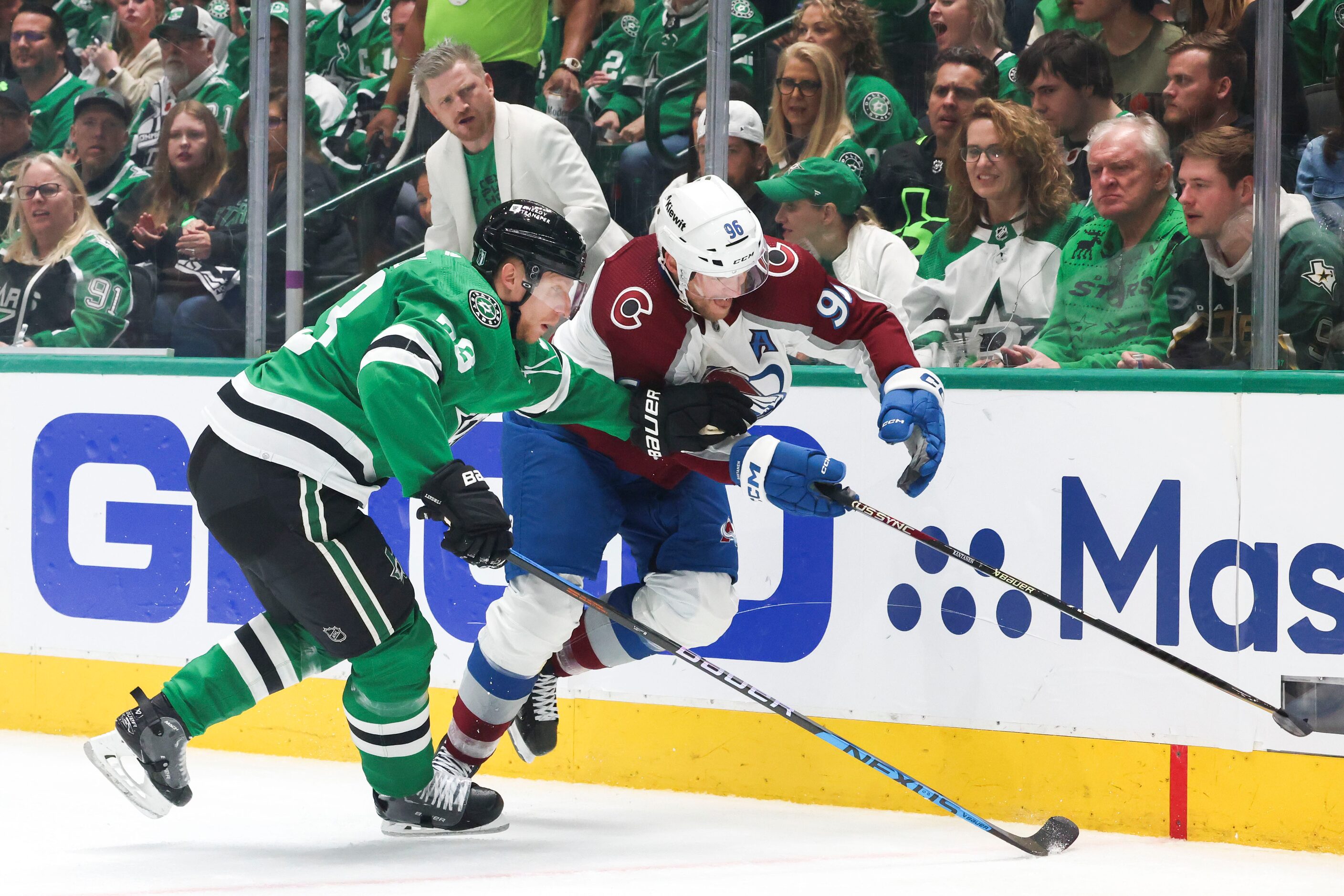 Dallas Stars defenseman Esa Lindell (left) competes for the puck against Colorado Avalanche...