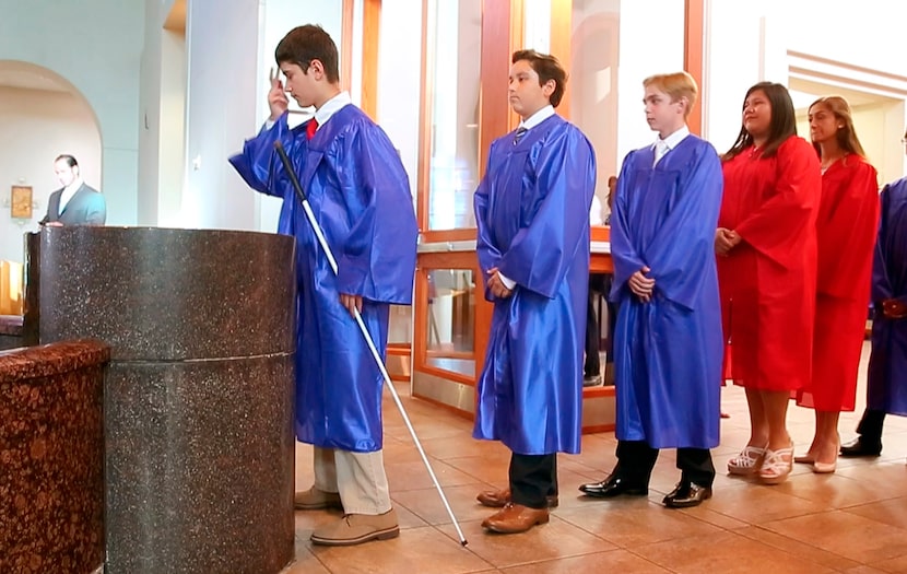 Zach makes the sign of the cross after taking holy water as he enters Mary Immaculate...