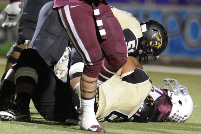Plano's Jake Eckeberger (50) and his teammates find themselves on the bridge between...