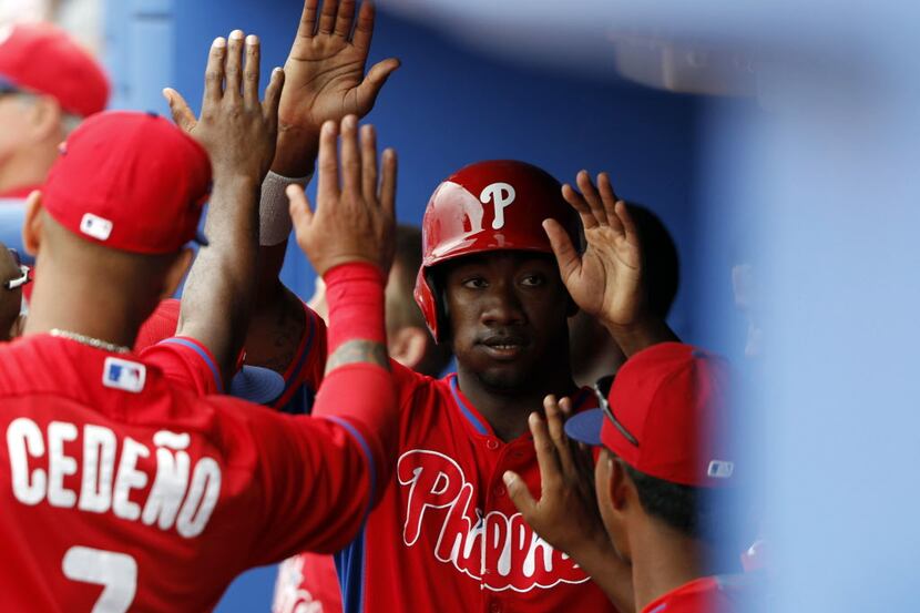 Philadelphia Phillies left fielder Domonic Brown (9) is congratulated by teammates after he...