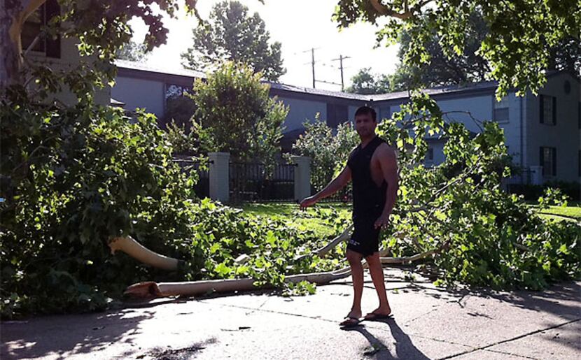A man surveys storm damage Wednesday morning on Lahoma Street in Oak Lawn, near where a  man...