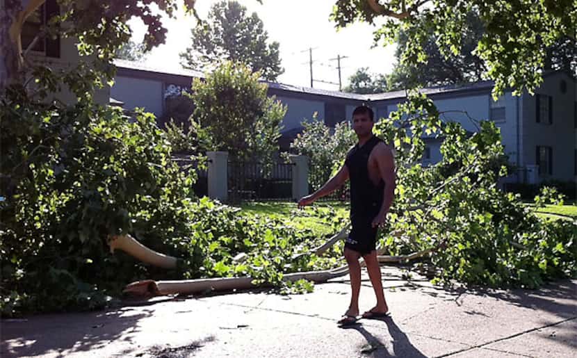 A man surveys storm damage Wednesday morning on Lahoma Street in Oak Lawn, near where a  man...