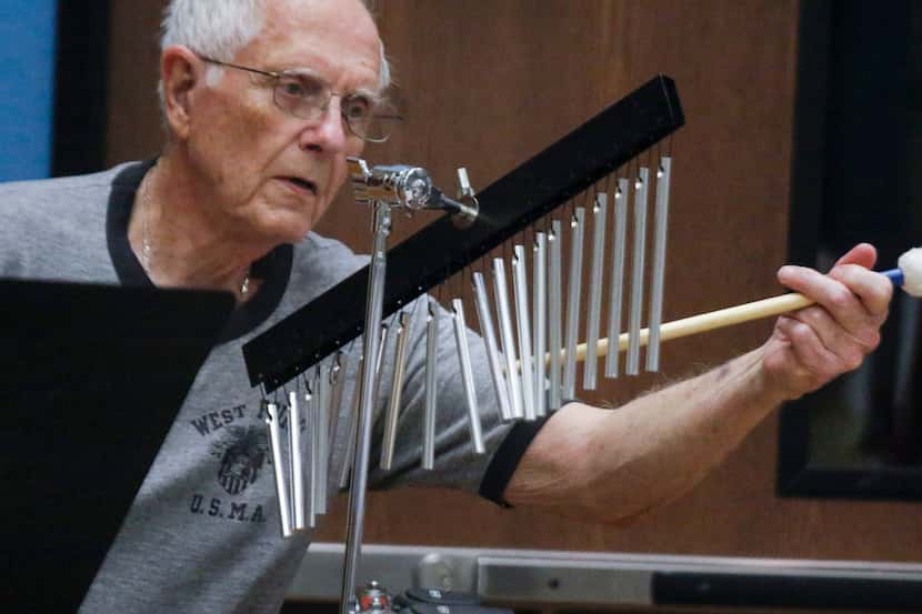 James Meine, 83, strikes a set of chimes at the Denton New Horizons Band rehearsal at the...