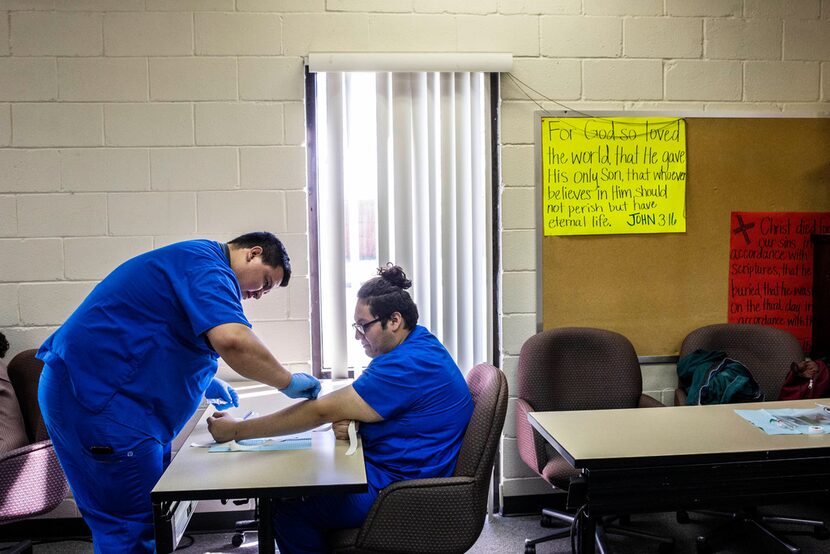 Student Asael Codiz draws blood from Miguel Valdez at West Dallas Community Church in Dallas.