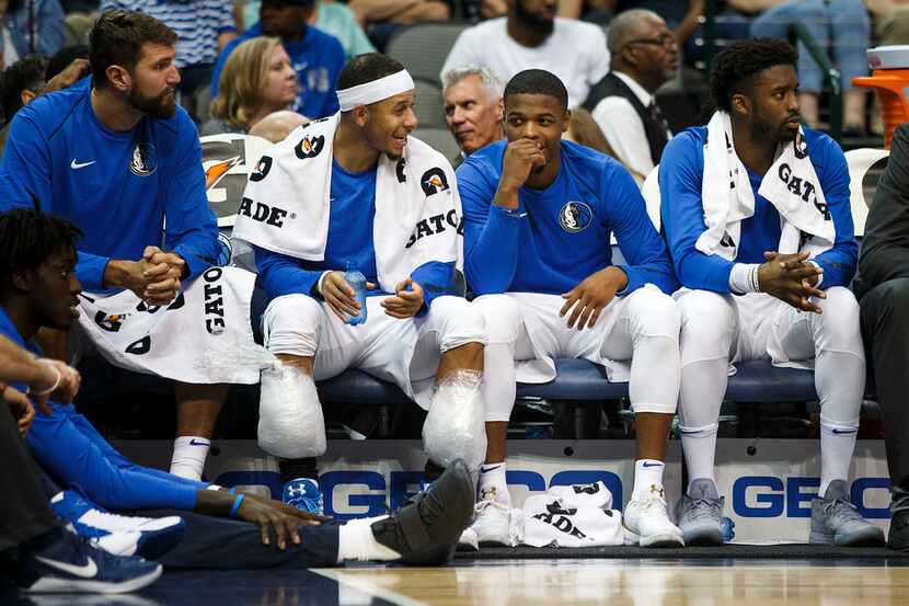 Dallas Mavericks guard Dennis Smith Jr. (center) watches from the bench during the first...