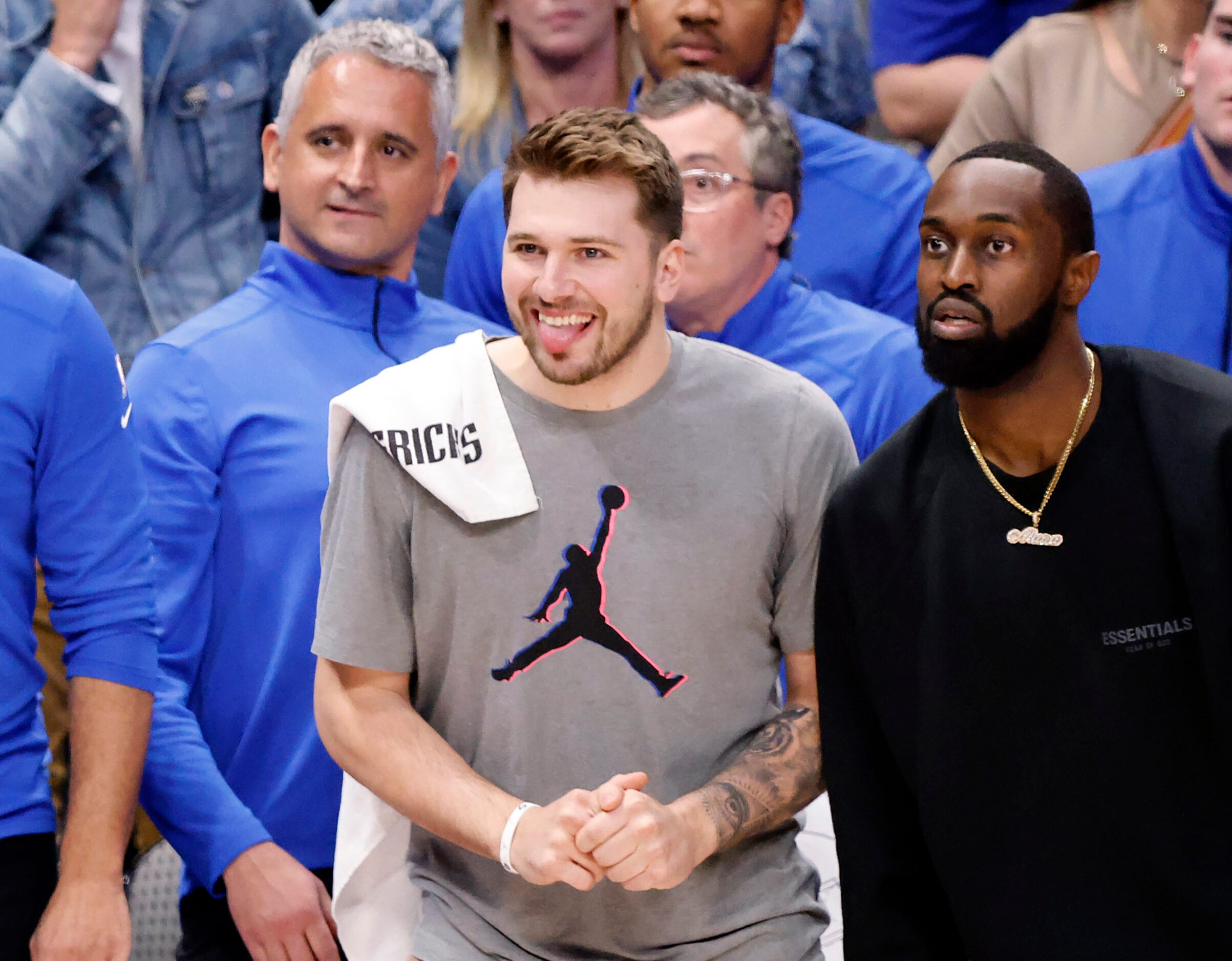 Dallas Mavericks injured guards Luka Doncic (center) and guard Theo Pinson (right) watch...