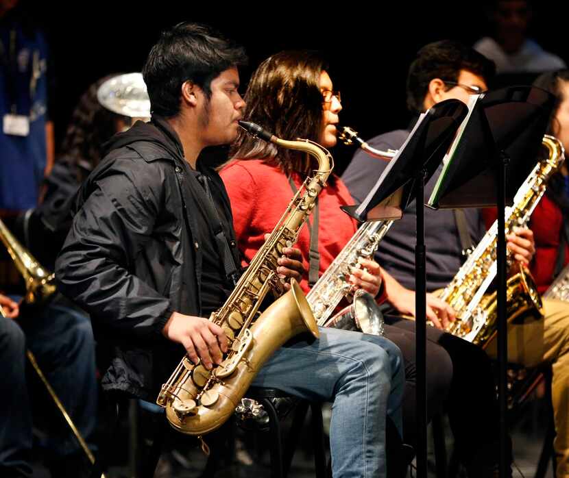 
Tenth-grader Kevin Gaspar plays the tenor saxophone in the Adamson High band during an...
