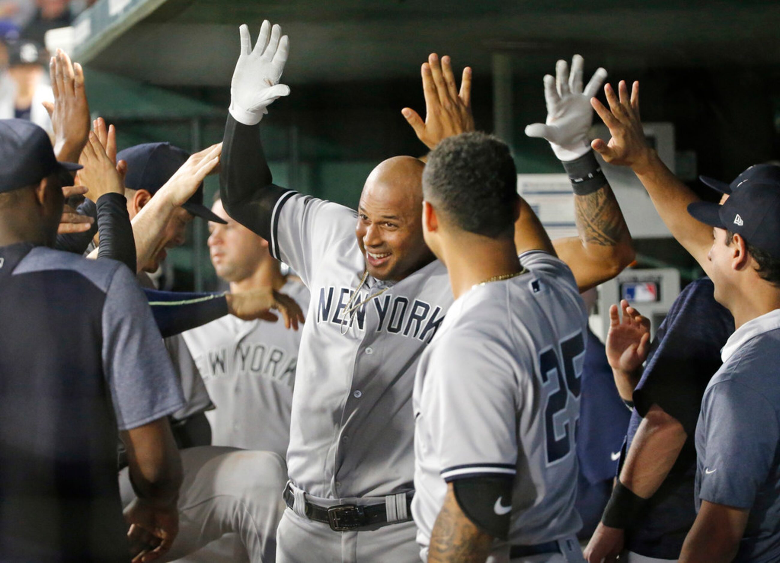 New York Yankees center fielder Aaron Hicks (31) is congratulated by teammates in the dugout...