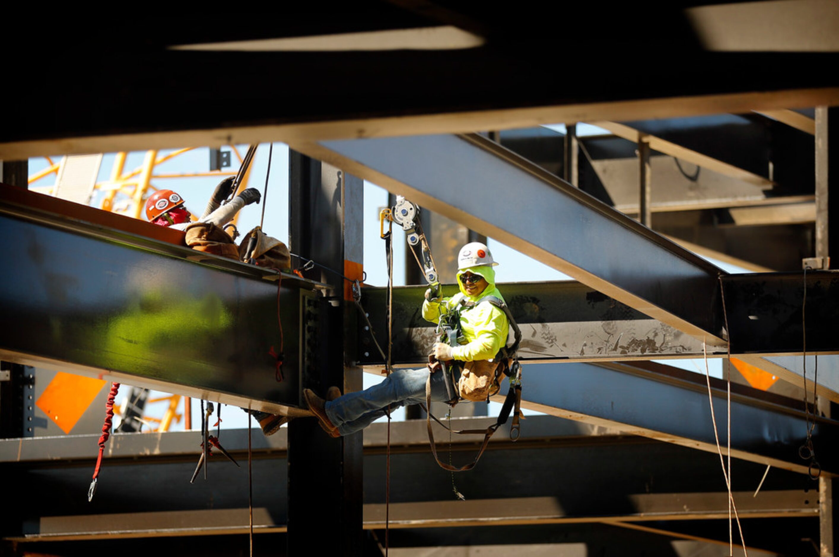 Construction workers work on support beams in the upper concourse of the new Globe Life...