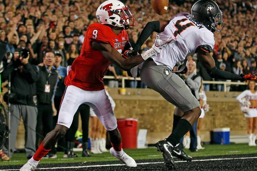 Oklahoma State's A.J. Green (4) interferes with Texas Tech's T.J. Vasher (9) during the NCAA...