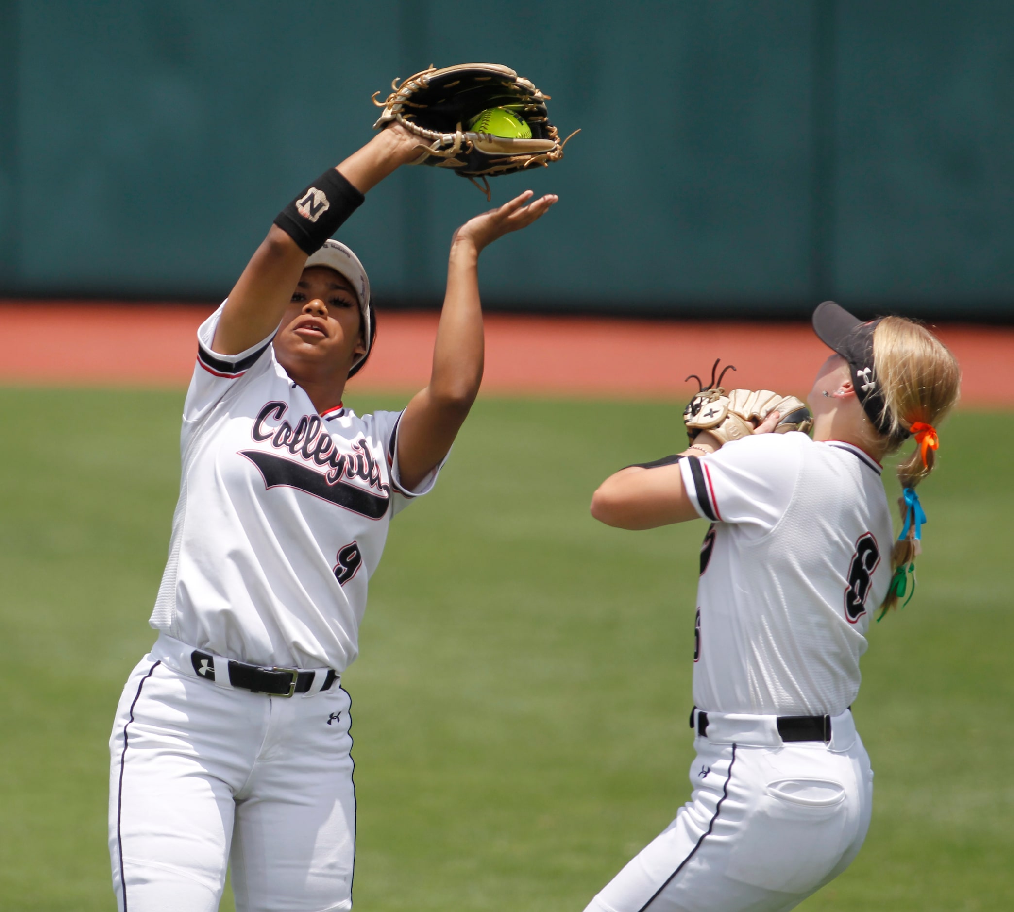 Colleyville Heritage center fielder DeNae Dickson (9), left, pulls in a fly ball as right...