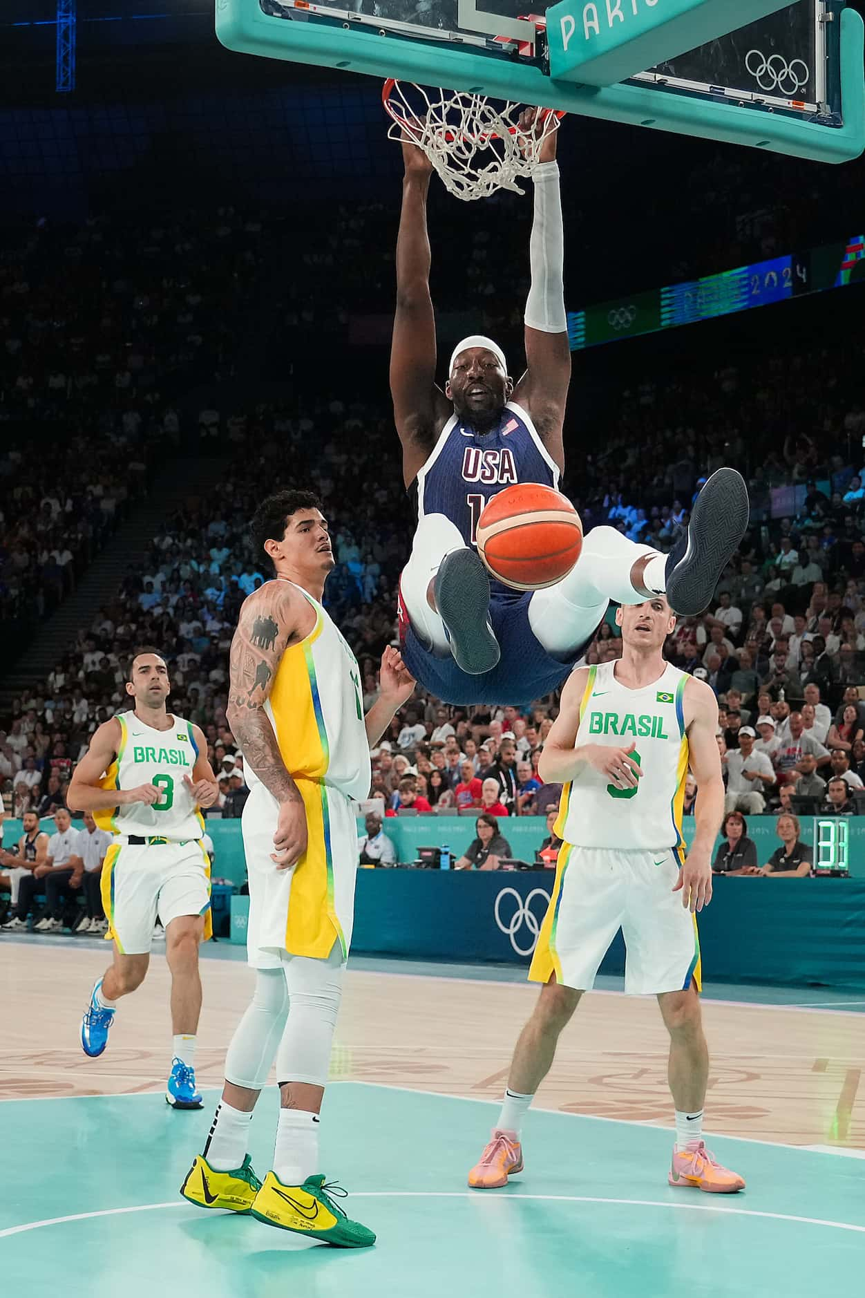 Bam Adebayo (13) of the United States dunks the ball past Gui Santos (11) and Marcelinho...