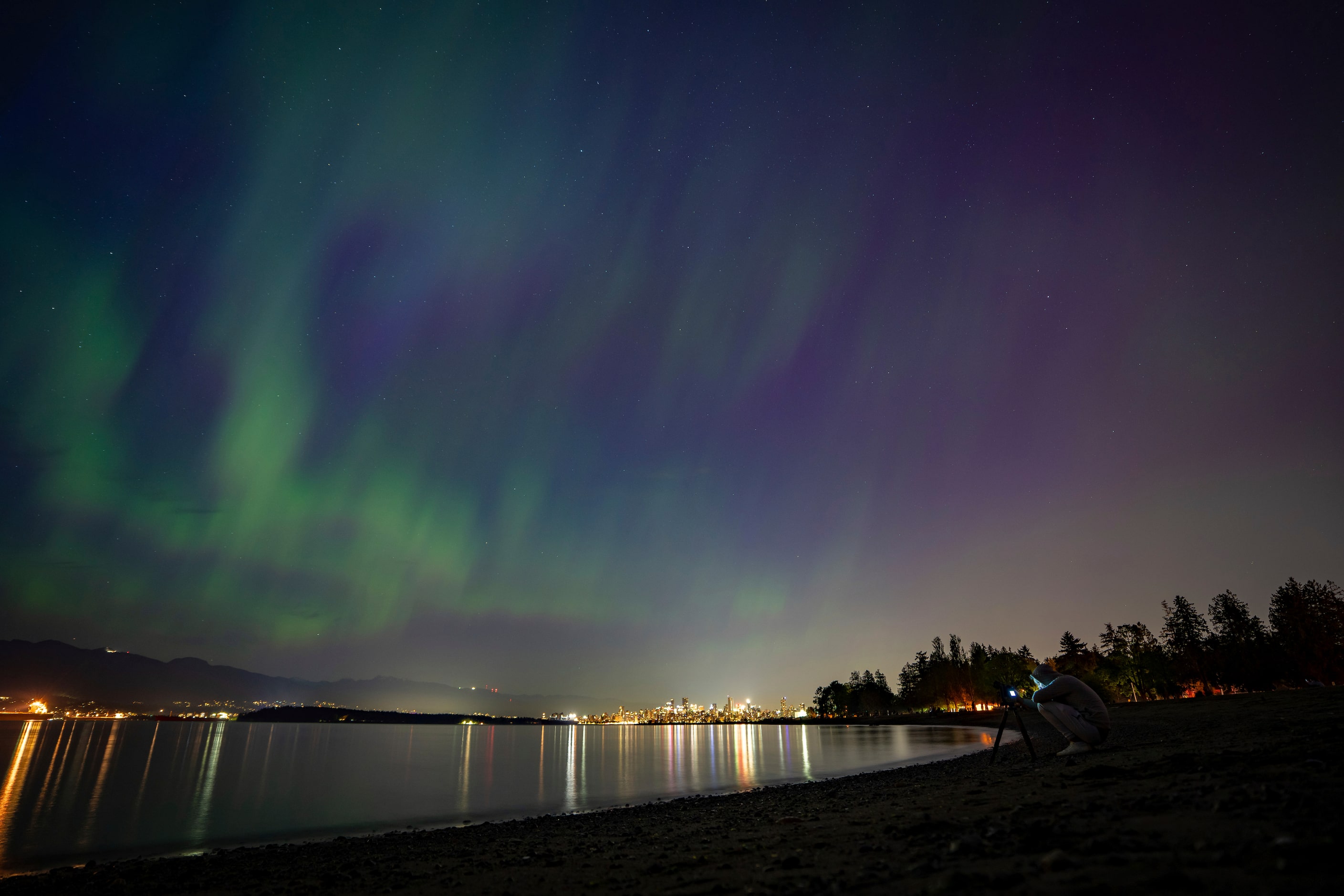 A person takes a photo of Aurora Borealis or the Northern Lights in Vancouver, B.C.,...