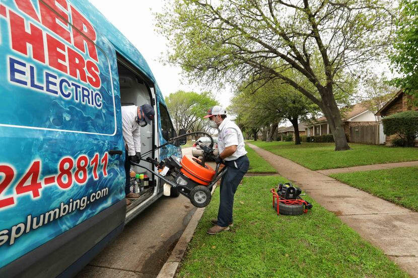 Garrett Bullard, left, and Dylan Ervin, with Baker Brothers, load the van after completing...