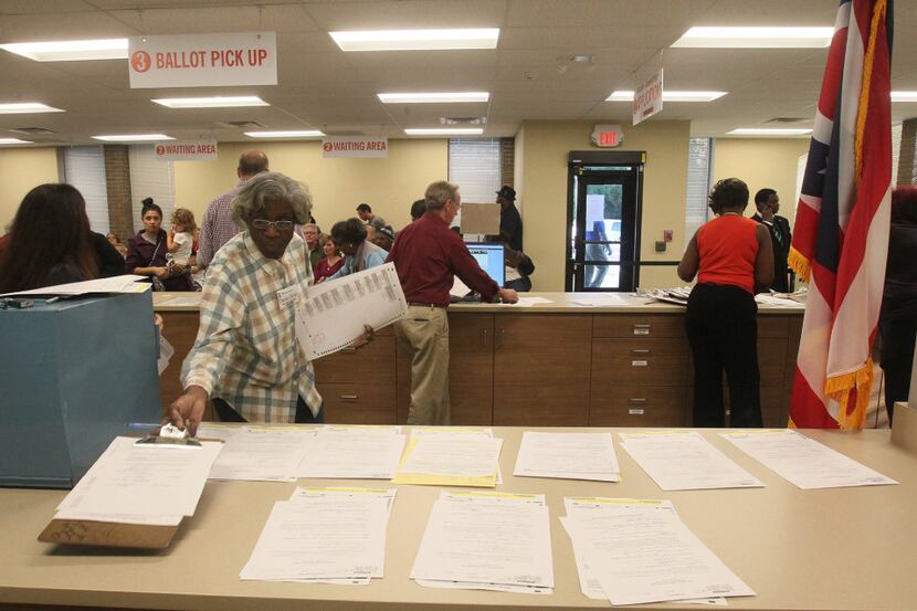 A board of elections worker pulls a ballot for a voter during early voting on Sunday, Nov....