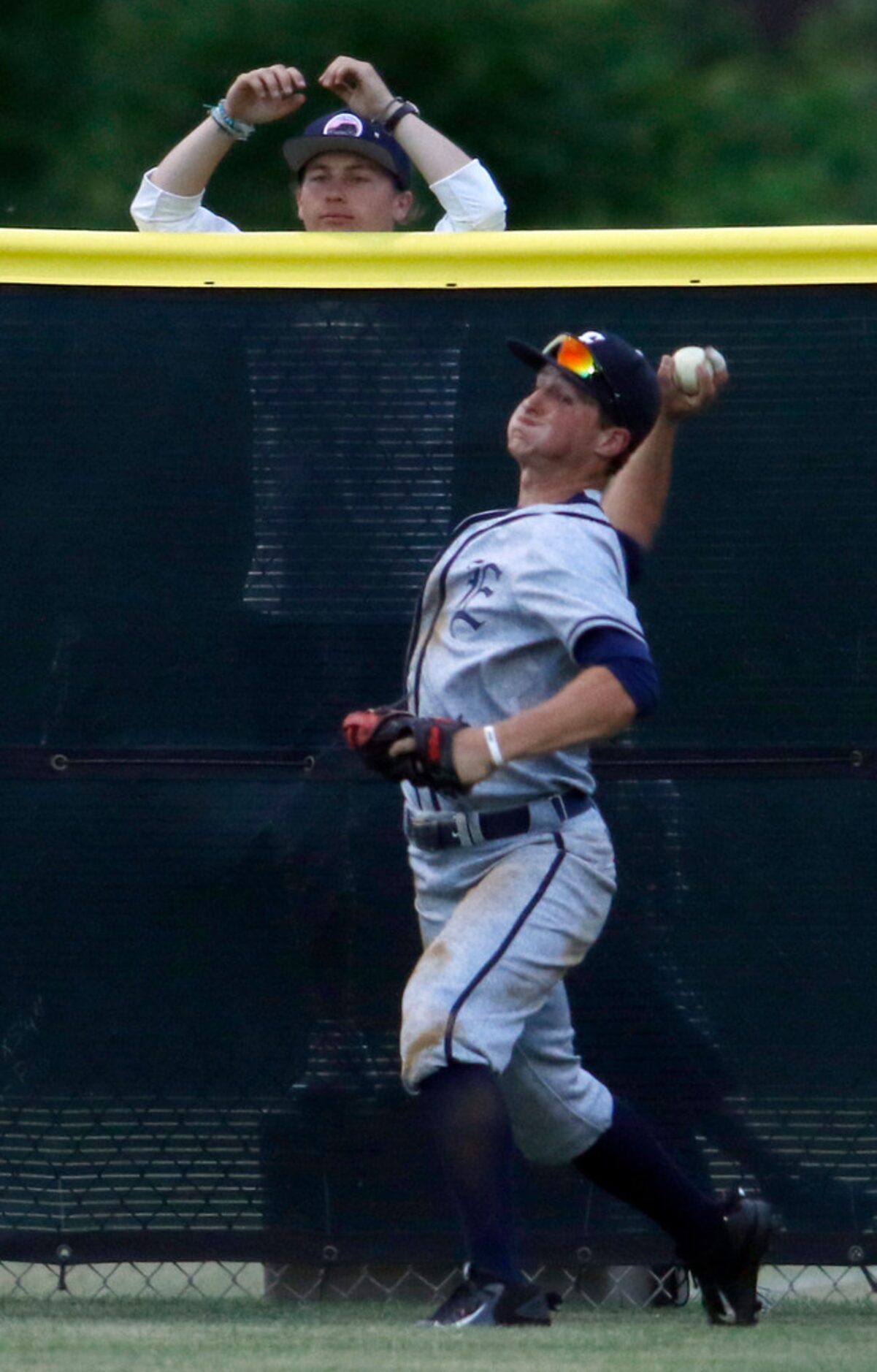 Northwest Eaton outfielder Jack Angus (9) returns the ball from just in front of the fence...