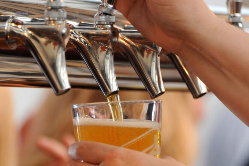 A bartender pours a cold brew at Lakewood Brewing Company's grand opening of the Taproom in...