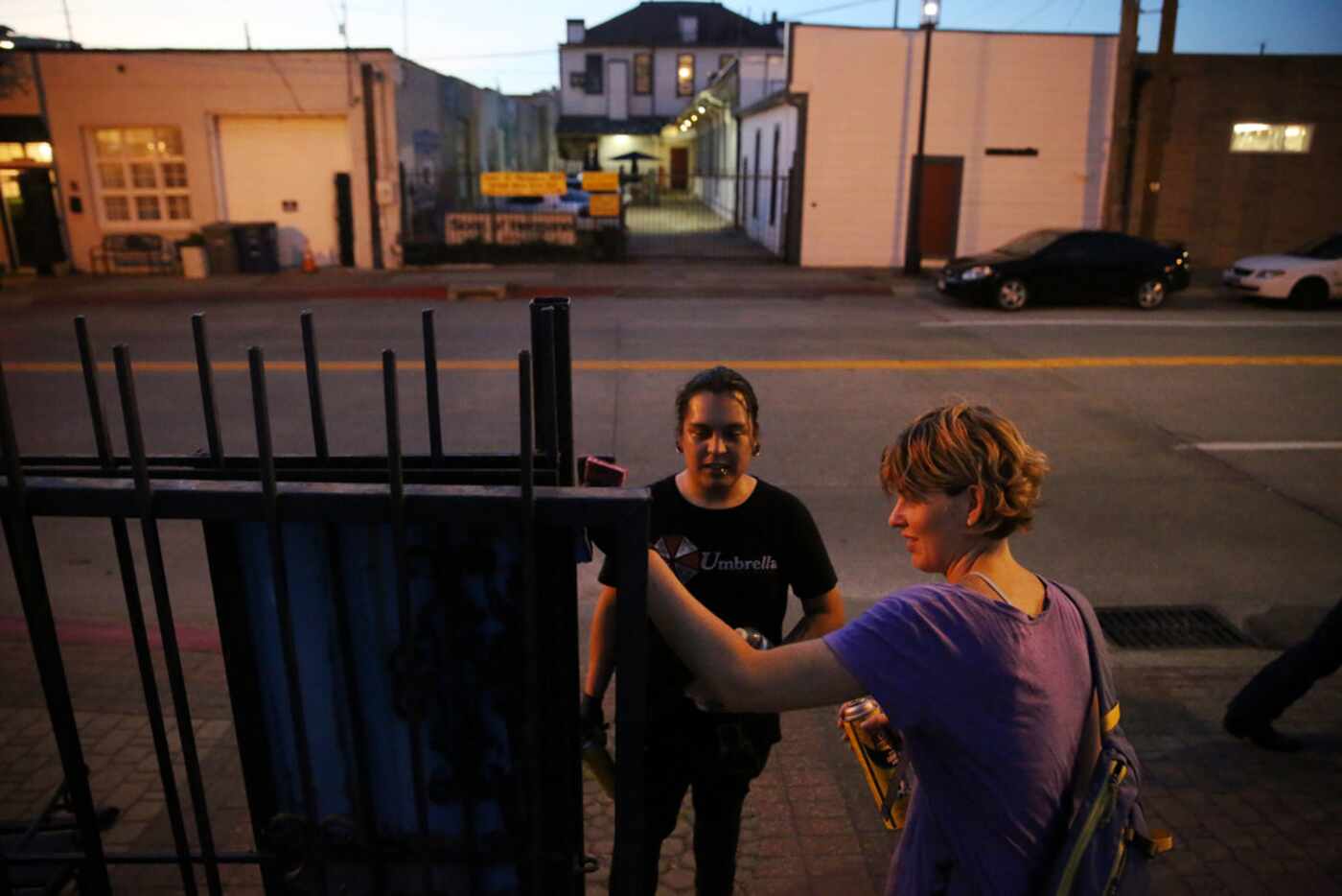 Angel Pacheco (center) and Adrienne Lichliter attempt to clean up a gate as community...