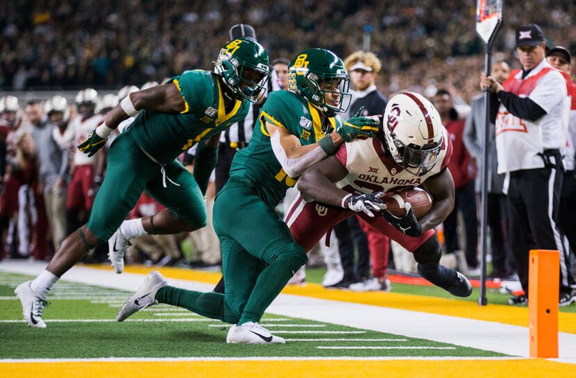 FILE - Baylor cornerbacks Grayland Arnold (1) and Raleigh Texada (13) push Oklahoma running...