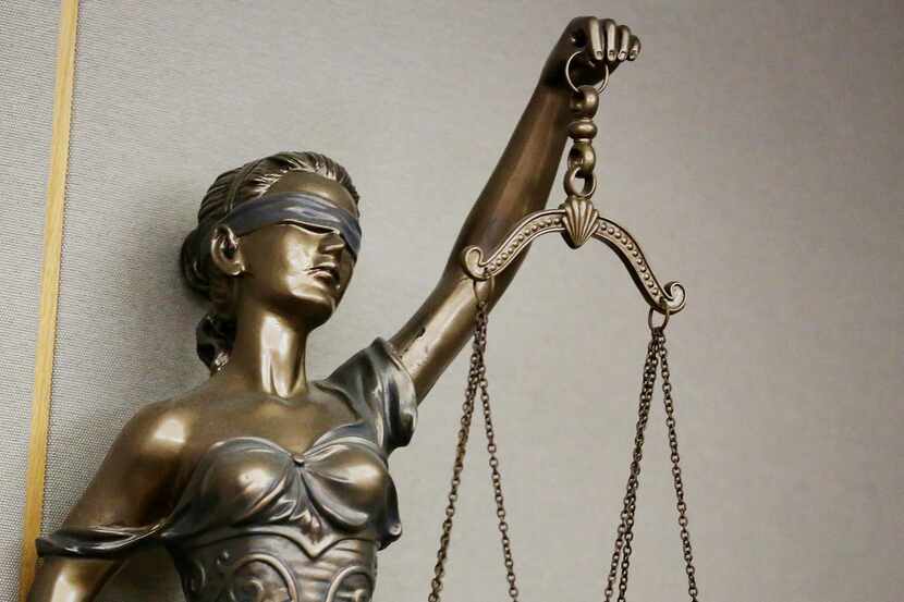 A statue of Lady Justice in a courtroom in the Frank Crowley Courts Building in Dallas...