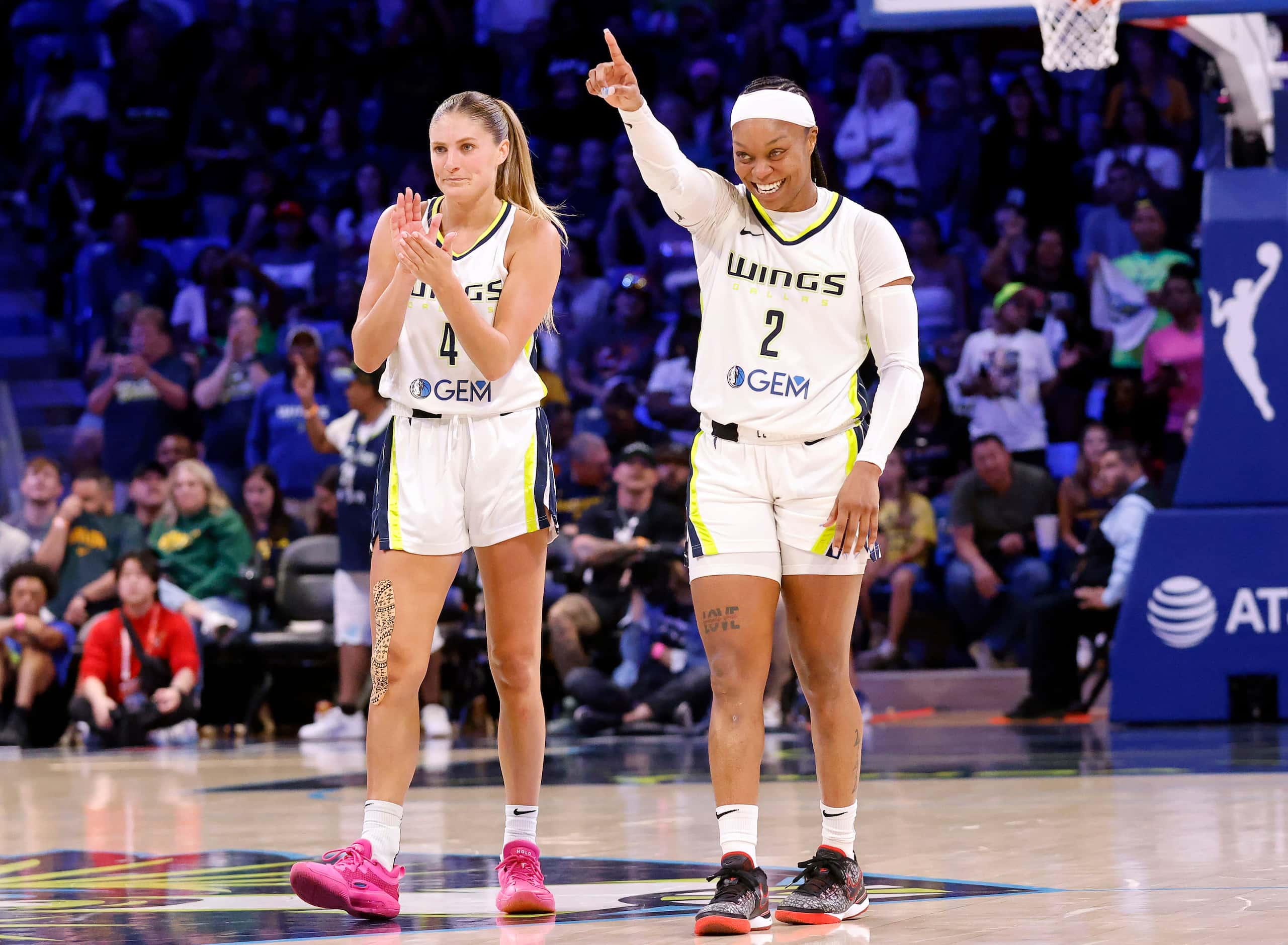 Dallas Wings guards Odyssey Sims (2) and Jacy Sheldon (4) begin to celebrate their win over...