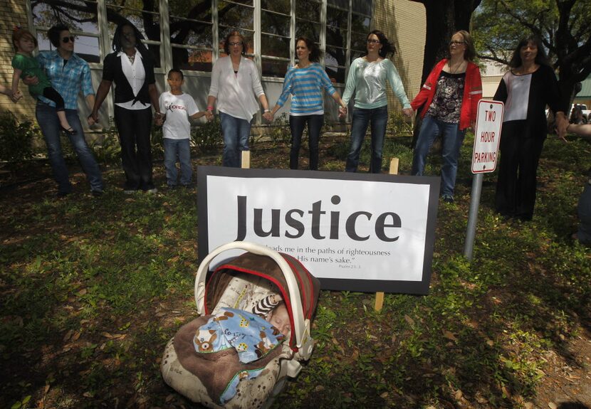 Angel Diaz, 3 months, daughter of Lorena Martinez, not pictured,  rests as other pray during...