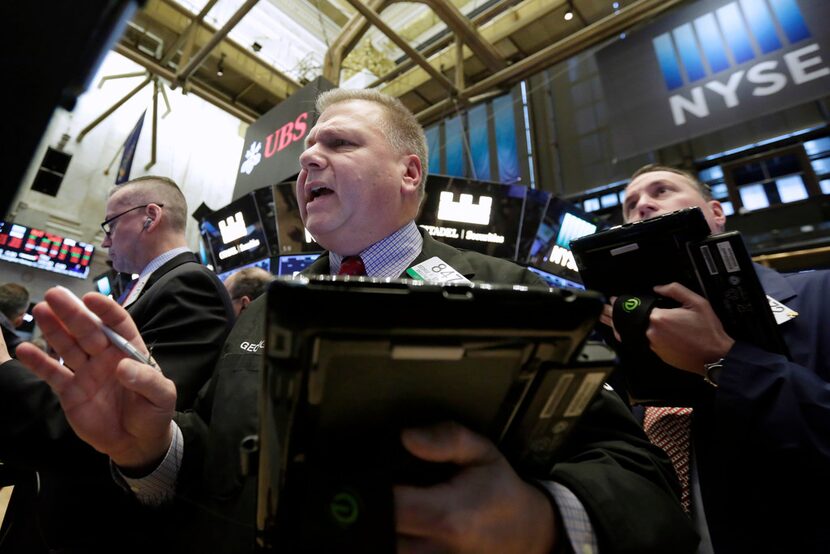 Trader George Ettinger, center, works on the floor of the New York Stock Exchange on...