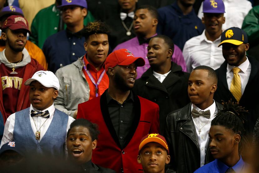 Dallas ISD athletes pose for a group photograph during the national signing day ceremony at...