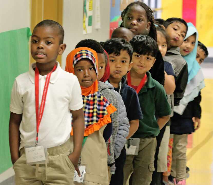 Kim Hakiza, left, leads the line of Adrian Rivera's kindergarten class as they wait in the...