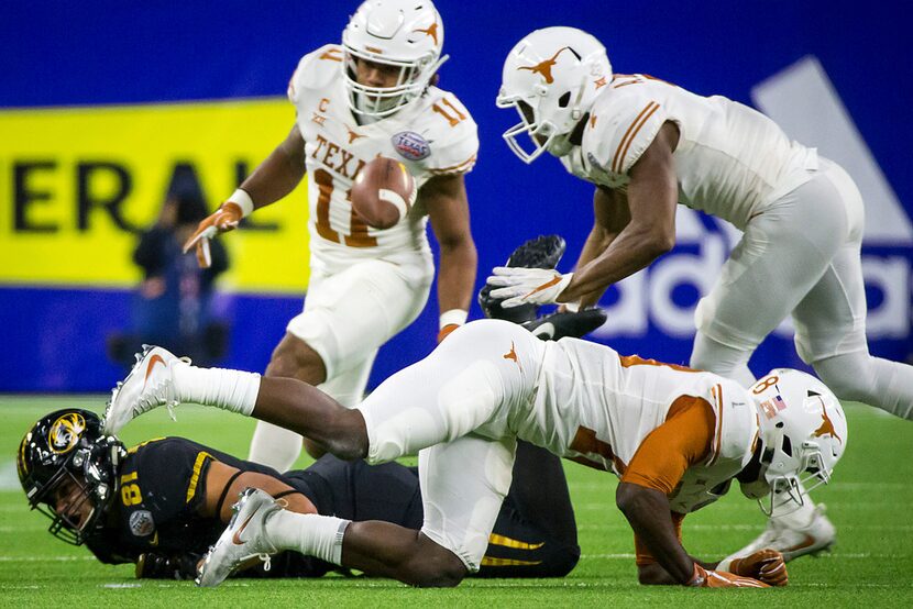 Missouri tight end Albert Okwuegbunam (81) fumbles after a hit from Texas defensive back...