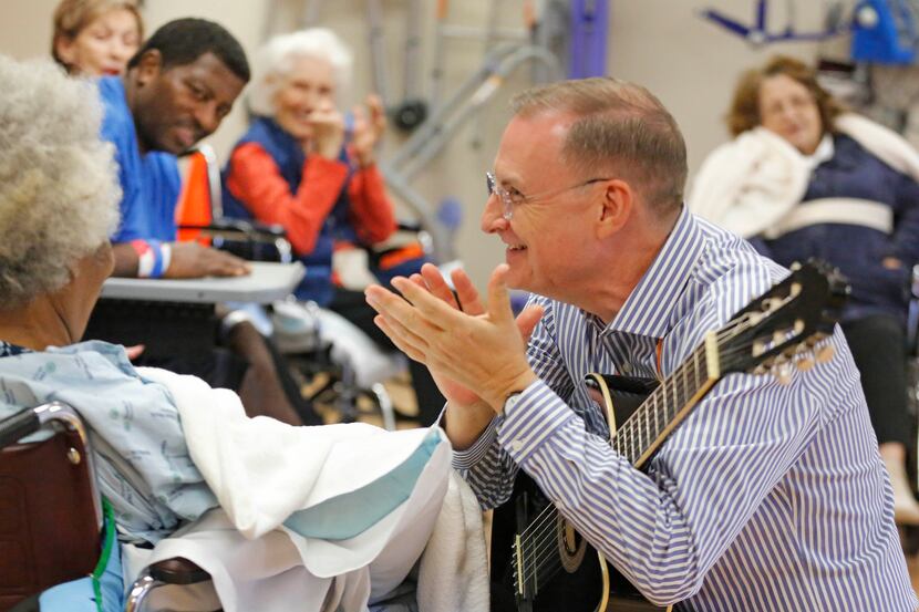 Michael Richardson, right, plays guitar and sings during a music therapy clinic at Texas...