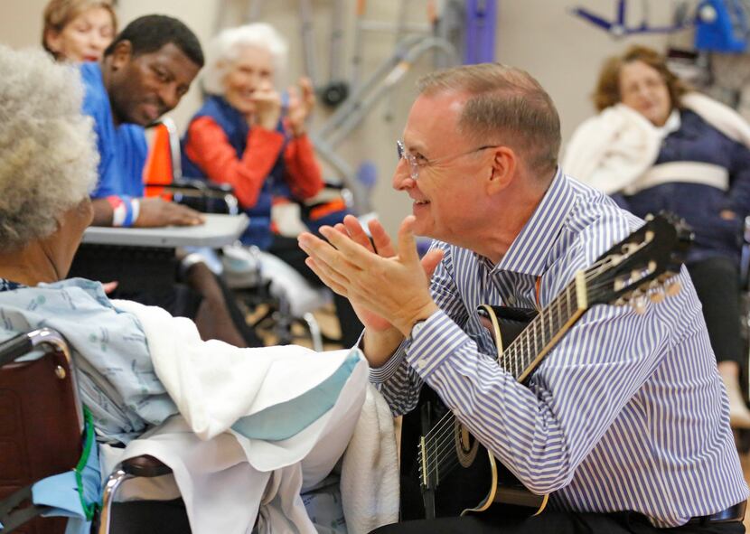 Michael Richardson, right, plays guitar and sings during a music therapy clinic at Texas...