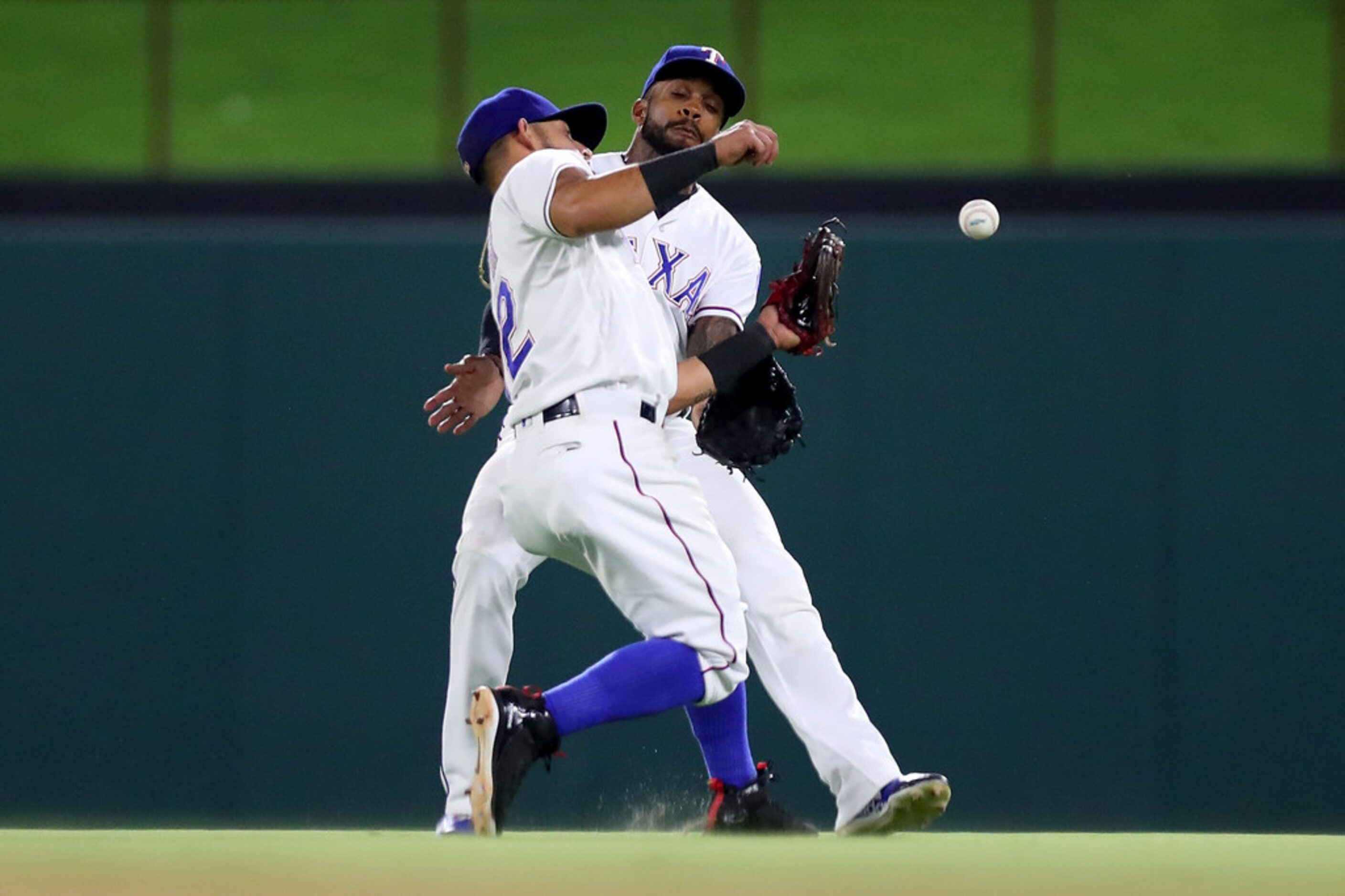 ARLINGTON, TX - JULY 23:  (L-R) Rougned Odor #12 of the Texas Rangers tries to field a fly...