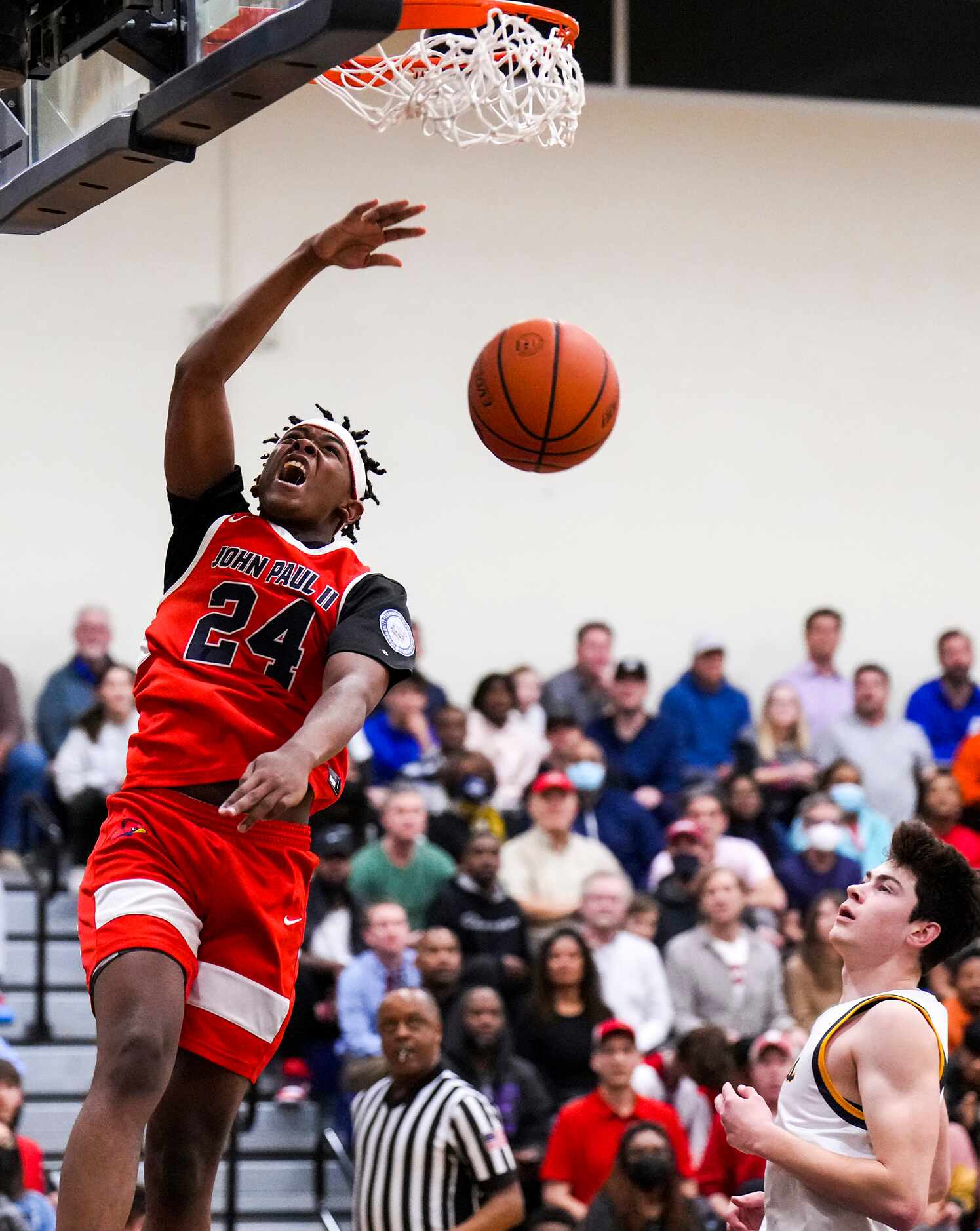 John Paul II's RJ Jones (24) dunks the ball past Prestonwood Christian's Christopher Wilson...