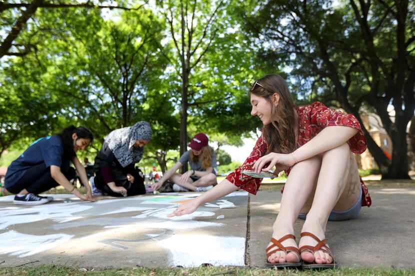 Courtney Thomas draws with chalk as part of the sidewalk chalk competition during Plano...