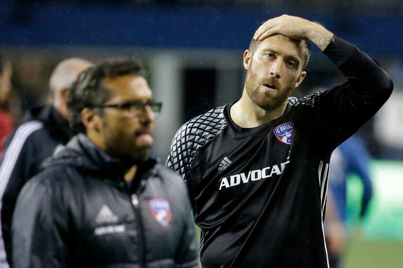 FC Dallas goalkeeper Chris Seitz, right, walks off the pitch after an MLS soccer playoff...