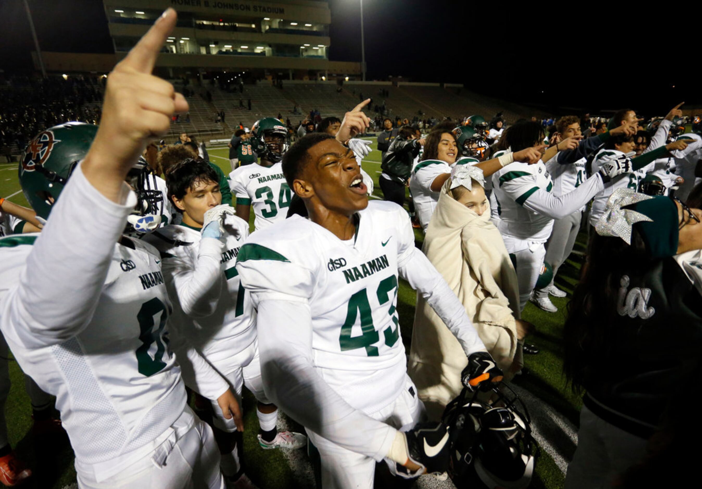 Naaman Forest players, including Nick Abengowe (43), celebrate their 42-27 win over Lakeview...