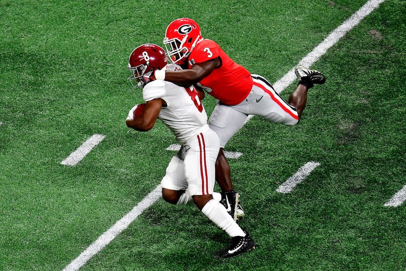 ATLANTA, GA - JANUARY 08:  Josh Jacobs #8 of the Alabama Crimson Tide is tackled by Roquan...