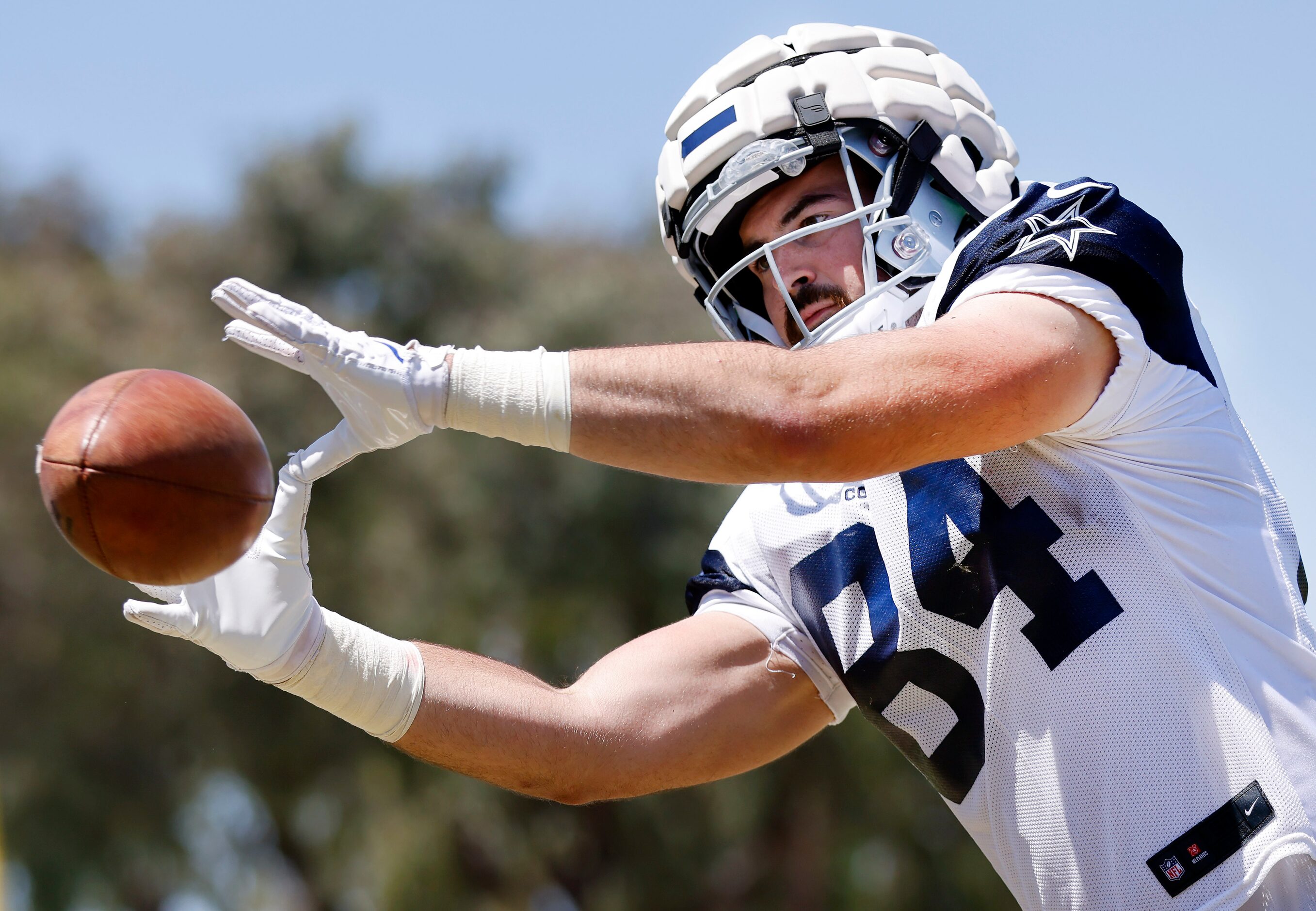 Dallas Cowboys tight end Sean McKeon (84) catches passes from a throwing machine at the end...