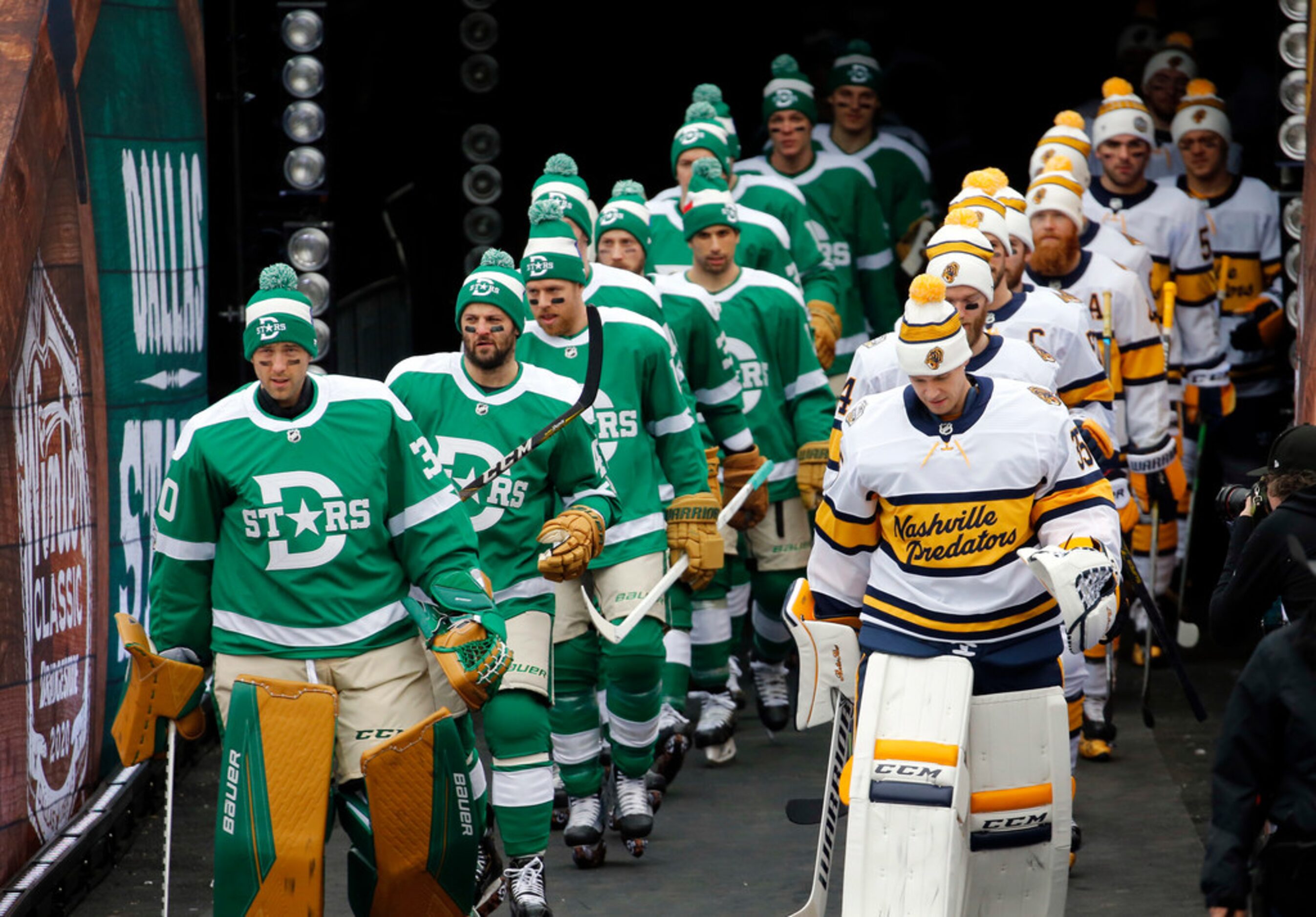 Dallas Stars and Nashville Predators players walk in single file line for warmups before...