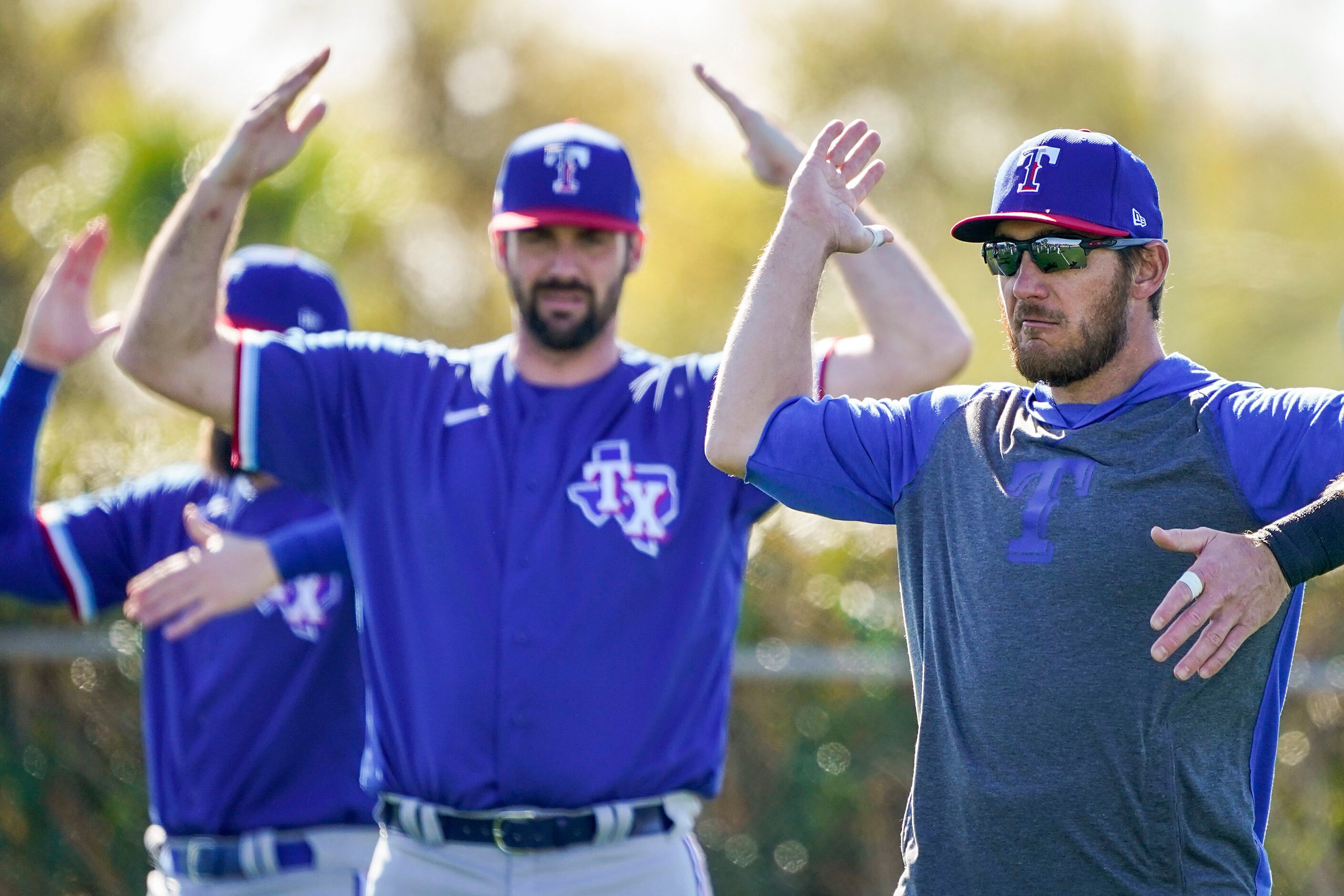 Texas Rangers catcher Jeff Mathis (right) stretches with teammates during a spring training...