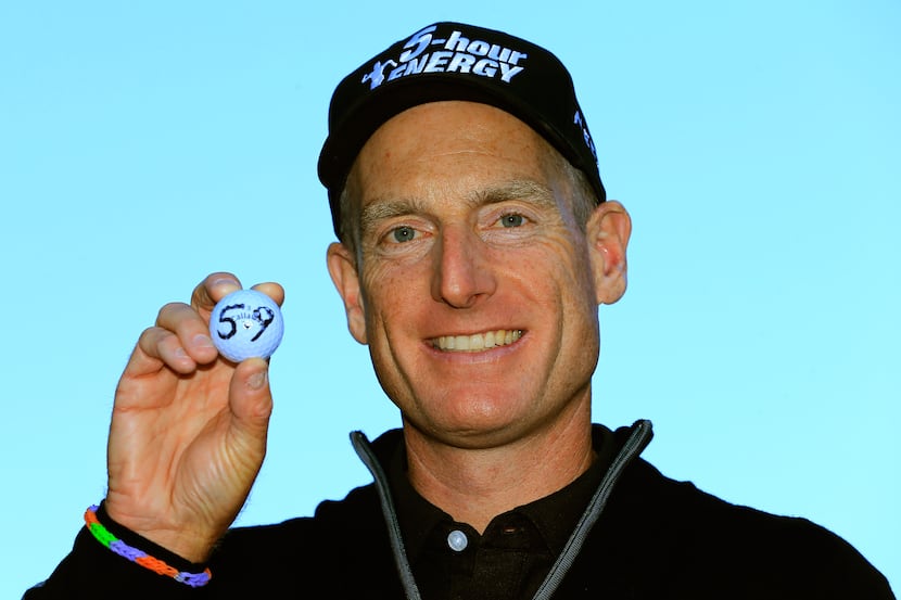 Jim Furyk holds up his ball with a '59' on it after shooting a 12-under round of 59 during...