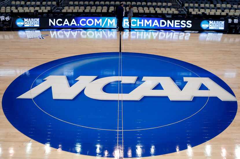 FILE - In this March 18, 2015, file photo, the NCAA logo is displayed at center court as...