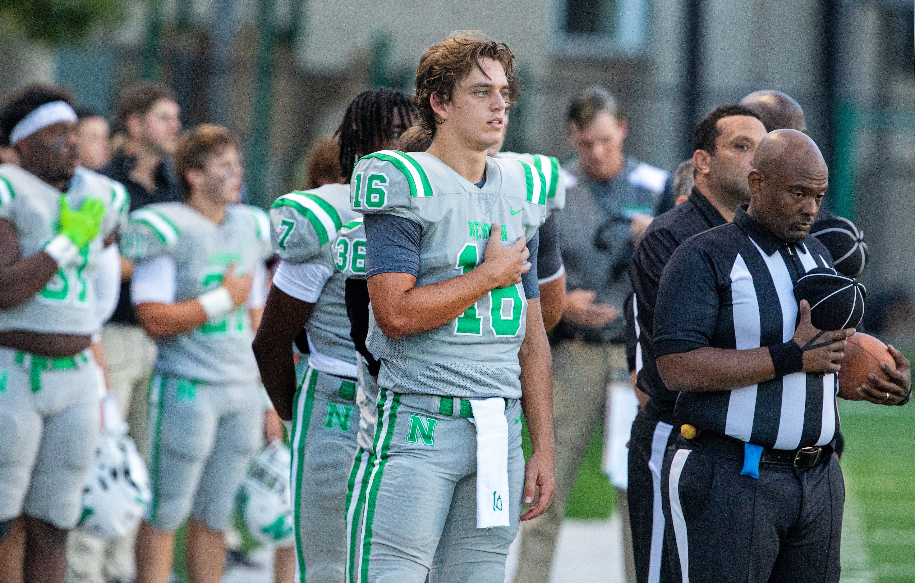 Arch Manning and teammates stand at attention during the National Anthem as Newman High...