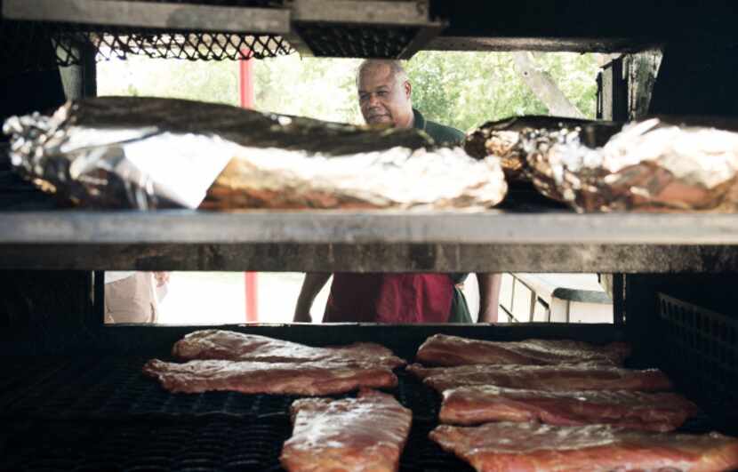 Owner and pit master Ben Washington checks his main pit at Whup's Boomerang Barbecue in Marlin.